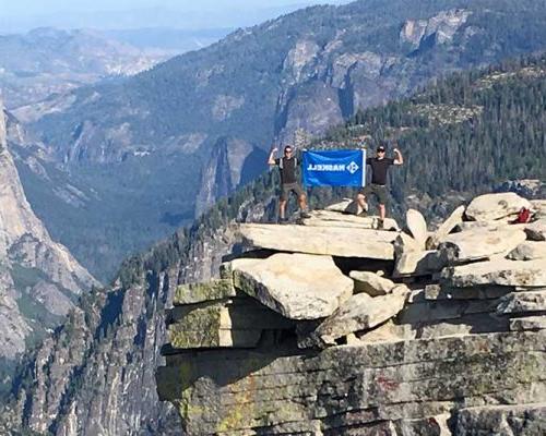 Livermore office employees hoist a 澳门足彩app flag atop Half Dome